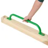 A hand holding a green climbing handle attached to a wooden beam. Náhled obrázku produktu