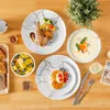 A table setting with a meal, including lamb chops, soup, fruit salad, and a waffle, arranged on plates with a decorative pattern. Náhled obrázku produktu
