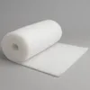 A roll of white, fluffy material is shown on a plain gray background. Produktbild-Vorschau