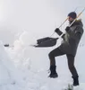 A man is shoveling snow in a snowy environment. Produktbild-Vorschau