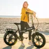 A woman posing with an electric bicycle on a beach. Anteprima dell’immagine prodotto