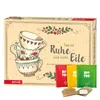 A tea advent calendar with stacked teacups and tea bags in front. Produktbild-Vorschau