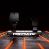 A ThrustMaster T598 steering wheel and pedal set is displayed against a dark background with orange light streaks. Anteprima dell’immagine prodotto