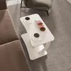 A C-shaped white side table with two cups of coffee and four donuts on a patterned rug next to a brown sofa. Anteprima dell’immagine prodotto