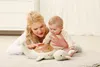A mother and baby are lying on a rug, interacting with a whale-shaped night light. Anteprima dell’immagine prodotto