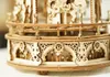 A close-up view of a wooden carousel model, focusing on the intricate details of its base and railing. Anteprima dell’immagine prodotto