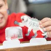 A child is playing with a toy tiger figure on ice blocks. Produktbild-Vorschau