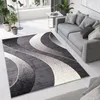A modern living room with a gray sofa and a patterned rug. Náhľad obrázku produktu