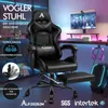 A black gaming chair with a footrest is shown in a room with colorful LED lighting. Produktbild-Vorschau
