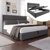 A bedroom scene with a bed and artwork on the wall, and an inset image showing the bed frame with its storage mechanism. Produktbild-Vorschau