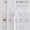 A close-up of a white fabric blind with text visible behind it. Produktbild-Vorschau