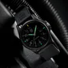 A close-up shot of a black Luminox watch with green luminous markings, set against a dark, textured background. Voir les images du produit