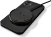 A black smartphone with a black wireless charging pad attached to its back. Produktbild-Vorschau