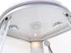 Close-up view of the ceiling of a modern shower cabin, showing a central shower head, two smaller jet nozzles, and a light. Produktbild-Vorschau