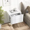 A white floating nightstand with two drawers is mounted on a wall next to a bed. A plant is visible on the left side of the image. Podgląd zdjęcia produktu