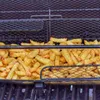 A close-up view of french fries in a grill basket. Podgląd zdjęcia produktu