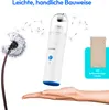 A hand holding a white handheld vacuum cleaner with a dandelion in the background and a beige storage bag to the side. Text is present at the top. Produktbild-Vorschau