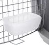 A close-up view of a white plastic food or water bowl attached to the wire mesh of a pet carrier. Podgląd zdjęcia produktu