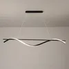 A modern black LED pendant light with a wavy design, suspended from the ceiling. Produktbild-Vorschau