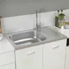 A stainless steel kitchen sink with a faucet and a draining board, set into white cabinets. Voir les images du produit