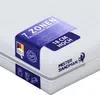 A close-up, angled view of a white mattress with a blue product tag attached. Produktbild-Vorschau