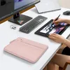A pink laptop sleeve is placed on a white desk next to a computer monitor, keyboard, drawing tablet, and a laptop. Produktbild-Vorschau