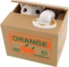 A coin bank shaped like a cardboard box with a cat peeking out and taking coins. Náhľad obrázku produktu