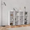 A white, three-shelf bookcase is shown in a room with a concrete wall and wooden floor. Produktbild-Vorschau
