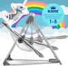 A baby swing with a raccoon pillow in front of a rainbow and clouds. Produktbild-Vorschau