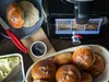 A kitchen scene with a food processor, freshly baked bread rolls, butter, and poppy seeds. Produktbild-Vorschau