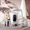 A white electric kettle with a digital display is placed on a table with a mug, a creamer pitcher, and coffee beans. Produktbild-Vorschau