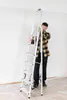A man is holding a ladder indoors, possibly preparing for painting or renovation. Náhled obrázku produktu