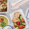 Overhead view of food containers and wooden cutlery on a textured surface. Anteprima dell’immagine prodotto