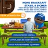 A picnic table set with a person sitting on a bench, surrounded by picnic items and crates. Produktbild-Vorschau