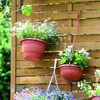 Hanging flower pots on a wooden fence. Produktbild-Vorschau