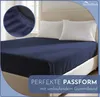 A navy blue fitted sheet on a bed with two white pillows. Produktbild-Vorschau