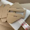 A collection of cardboard packaging materials, including folded boxes and protective bubble wrap, laid out on a wooden surface. Produktbild-Vorschau
