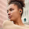 A woman wearing black wireless earbuds, with a building in the background. Anteprima dell’immagine prodotto