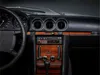 Close-up view of a car's dashboard, focusing on the center console with a vintage radio and wood trim. Voir les images du produit