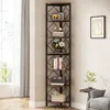A tall corner bookshelf filled with decorative items and books, placed in a room next to a window and a chair. Podgląd zdjęcia produktu