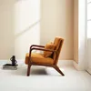 A mid-century modern armchair in ochre velvet with a wooden frame, placed on a white floor against a cream wall. Anteprima dell’immagine prodotto