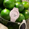 A pink Casio G-Shock watch is placed in front of a basket of green limes, with a pair of white sunglasses in the foreground. Produktbild-Vorschau