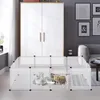 A white plastic pet enclosure with two cats inside, placed in a living room setting next to a large white wardrobe and a sofa. Voir les images du produit