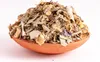A close-up shot of a pile of dried herbs and plant matter in a small terracotta bowl. Produktbild-Vorschau
