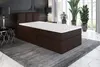 A dark brown boxspring bed with a white mattress and topper is shown in a bedroom setting with plants and lamps. Produktbild-Vorschau
