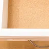 Close-up view of the inside of a drawer with a cork liner and a white drawer front. Produktbild-Vorschau