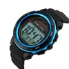 A close-up, angled shot of a digital sports watch with a black band and a blue bezel. The watch face displays the time and other digital information. Produktbild-Vorschau