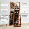 A wooden jewelry cabinet with a mirror, open to display its interior compartments and features, with labels pointing to different sections. Voir les images du produit