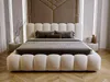 A modern bedroom with a large upholstered bed as the focal point. Produktbild-Vorschau
