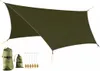 A green tarp is spread out, with accessories like bags and stakes laid out beside it. Náhled obrázku produktu